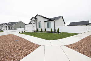 Modern farmhouse featuring a front yard and fence