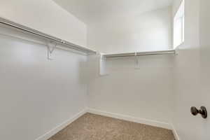 PHOTOS FROM SIMILAR HOME. OPTIONS AND FINISHES WILL VARY. Walk in closet bedroom 2 featuring light colored carpet