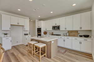 PHOTOS FROM SIMILAR HOME. OPTIONS AND FINISHES WILL VARY. Kitchen with light wood-type flooring, appliances with stainless steel finishes, a sink, and recessed lighting