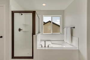 PHOTOS FROM SIMILAR HOME. OPTIONS AND FINISHES WILL VARY. Primary suite bathroom featuring a stall shower and a garden tub
