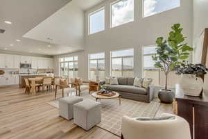 PHOTOS FROM SIMILAR HOME. OPTIONS AND FINISHES WILL VARY. Living area featuring recessed lighting, light wood-style flooring, a high ceiling, and visible vents