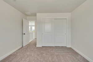 PHOTOS FROM SIMILAR HOME. OPTIONS AND FINISHES WILL VARY. Bedroom 3 with a closet, carpet flooring, and baseboards