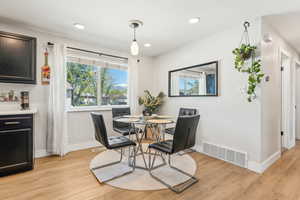 Dining space with light wood-style flooring, visible vents, baseboards, and recessed lighting