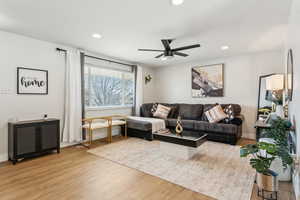 Living area with recessed lighting, light wood finished floors, baseboards, and a ceiling fan