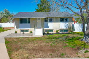 View of front of home with a front yard and fence