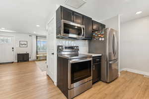 Kitchen with light wood-style flooring, appliances with stainless steel finishes, recessed lighting, and baseboards