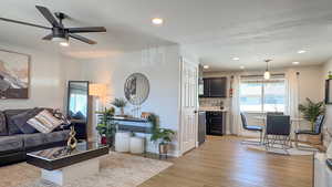 Living room featuring recessed lighting, light wood-type flooring, baseboards, and ceiling fan