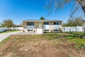 View of front of property featuring a front lawn and fence