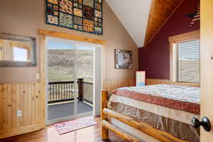 Bedroom featuring wood walls, wood flooring, and a wainscoted wall