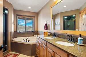 Bathroom with a oversized shower stall, double vanity, and a garden tub