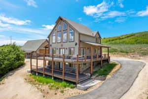Rear view of house featuring stucco siding and a deck