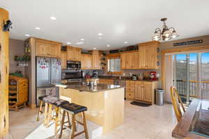 Kitchen featuring  tile flooring, a kitchen bar, and appliances with stainless steel finishes