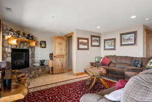 Living area featuring recessed lighting, a fireplace, and light tile flooring