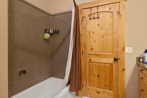 Bathroom featuring shower / bath combination with curtain and vanity