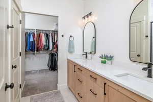 Bathroom featuring double vanity, a sink, and a spacious closet