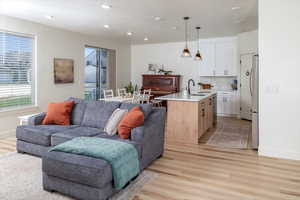 Living area featuring recessed lighting, light wood-style floors, and baseboards