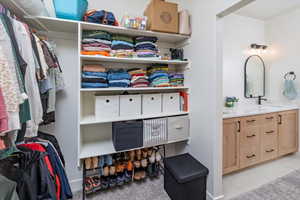 Spacious closet with light tile patterned floors and a sink