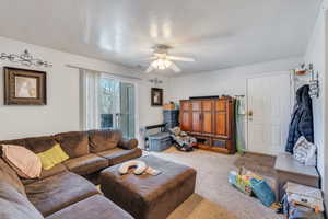 Living area featuring carpet and a ceiling fan