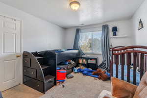 Carpeted bedroom featuring visible vents and a textured ceiling