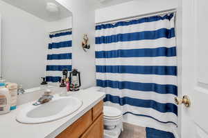 Bathroom with a shower with shower curtain, vanity, and toilet