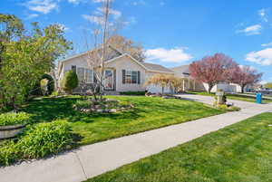 Ranch-style house with an attached garage, driveway, and a front lawn