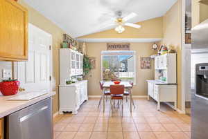 Kitchen featuring light countertops, a ceiling fan, light tile patterned flooring, lofted ceiling, and dishwasher