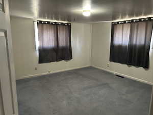 Spare room featuring visible vents, baseboards, and carpet