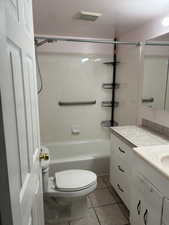 Full bathroom with visible vents, toilet, vanity, tile patterned floors, and bathing tub / shower combination