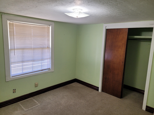 Unfurnished bedroom featuring baseboards, a closet, carpet flooring, a textured ceiling, and visible vents