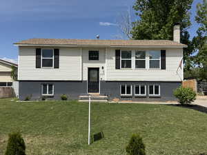 Split foyer home with a chimney and brick siding
