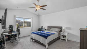 Bedroom with ceiling fan, visible vents, light carpet, lofted ceiling, and baseboards