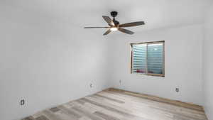Unfurnished room with wood finished floors and a ceiling fan
