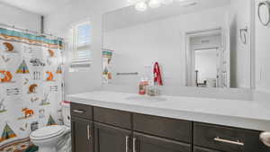 Full bathroom with visible vents, toilet, curtained shower, and vanity