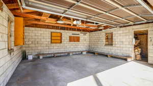 Garage featuring concrete block wall and a garage door opener