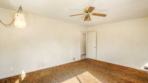 Unfurnished room with ceiling fan, baseboards, carpet flooring, and visible vents