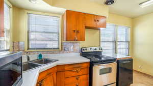 Kitchen with stainless steel appliances, a wealth of natural light, visible vents, and light countertops