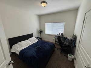 Bedroom with a textured ceiling and carpet