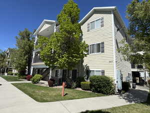 View of front of house with stairs and a front yard