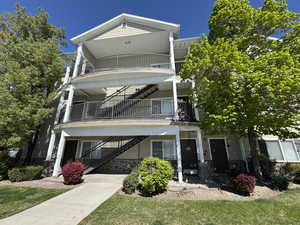 View of front of property with stairs and stone siding