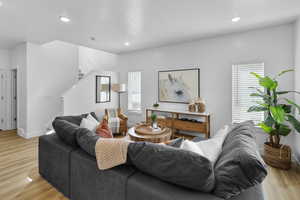 Living room featuring recessed lighting, stairway, and light wood-style floors