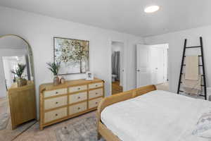 Bedroom featuring ensuite bath and light colored carpet
