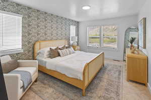 Bedroom featuring visible vents, baseboards, light carpet, and wallpapered walls