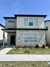 View of modern front facade with stucco siding and stone siding