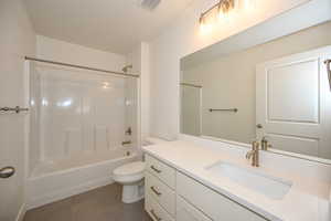 Full bathroom with vanity, bathing tub / shower combination, tile patterned flooring, toilet, and visible vents