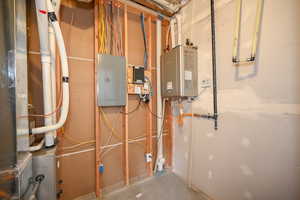 Utility room featuring electric panel and water heater