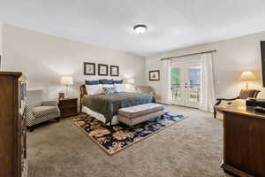 Carpeted bedroom with french doors and access to outside