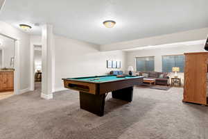 Recreation room with baseboards, a sink, a textured ceiling, carpet floors, and billiards
