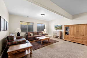 Living room with light colored carpet, baseboards, and visible vents