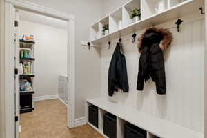 Mudroom with light tile patterned floors and baseboards