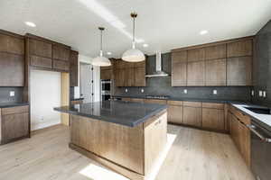 Kitchen featuring stainless steel appliances, light wood-type flooring, decorative backsplash, pendant lighting, and recessed lighting